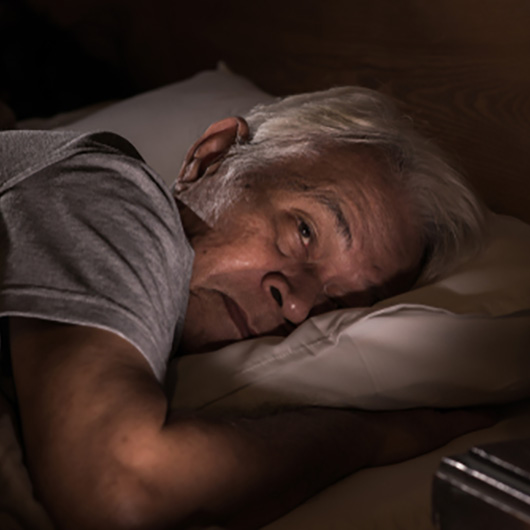 A person laying awake at night suffering from sleep disorders.